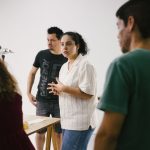 Grupo de pessoas reunido em um estúdio, discutindo ideias e desenvolvendo um projeto criativo.