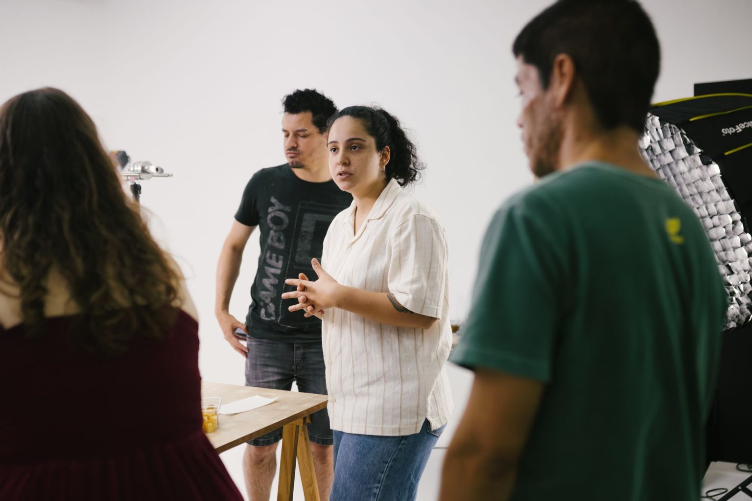 Grupo de pessoas reunido em um estúdio, discutindo ideias e desenvolvendo um projeto criativo.