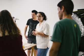 Grupo de pessoas reunido em um estúdio, discutindo ideias e desenvolvendo um projeto criativo.