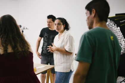 Grupo de pessoas reunido em um estúdio, discutindo ideias e desenvolvendo um projeto criativo.