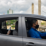 Motorista de aplicativo conduz veículo enquanto passageiro utiliza celular durante deslocamento urbano em Rondônia