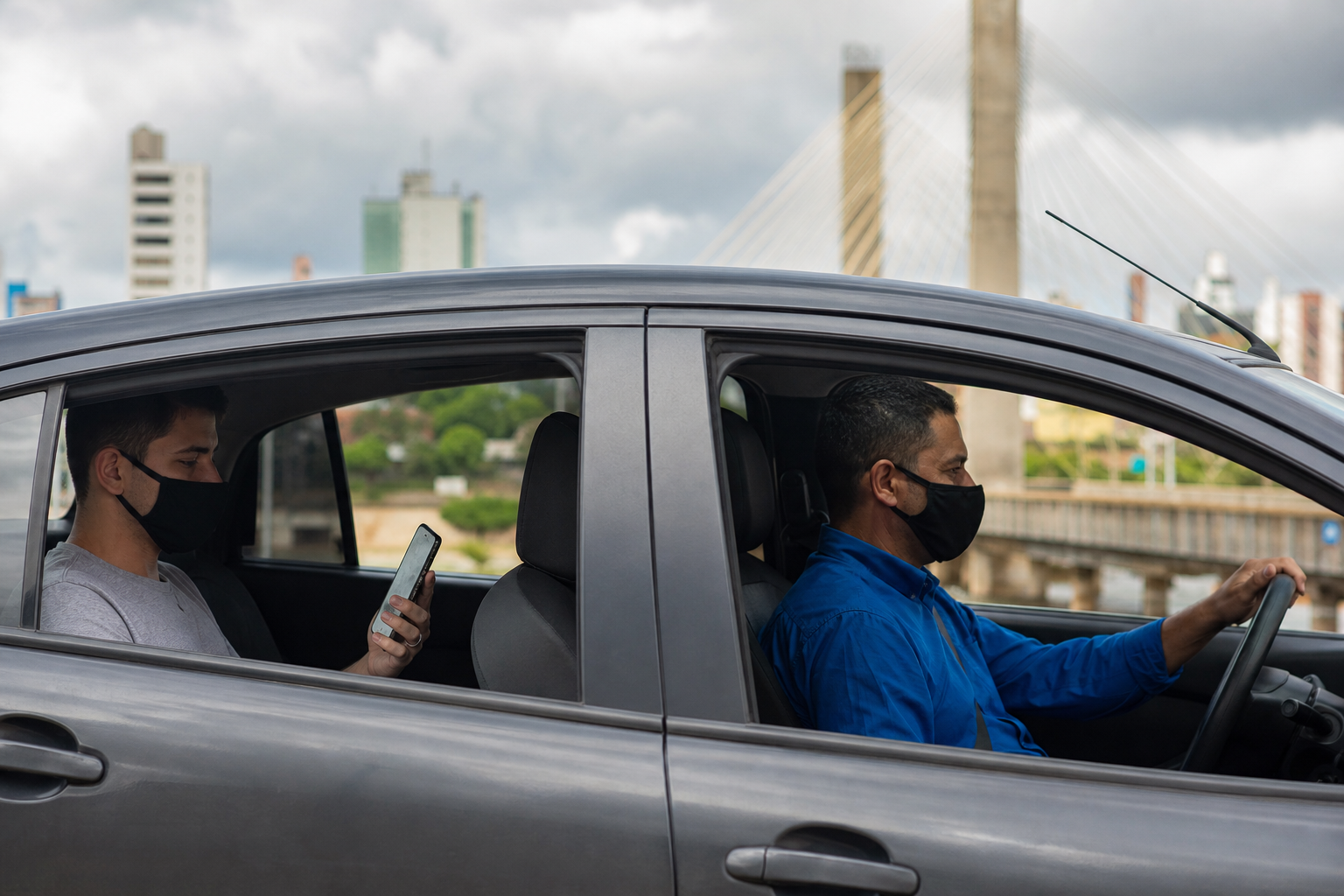 Motorista de aplicativo conduz veículo enquanto passageiro utiliza celular durante deslocamento urbano em Rondônia