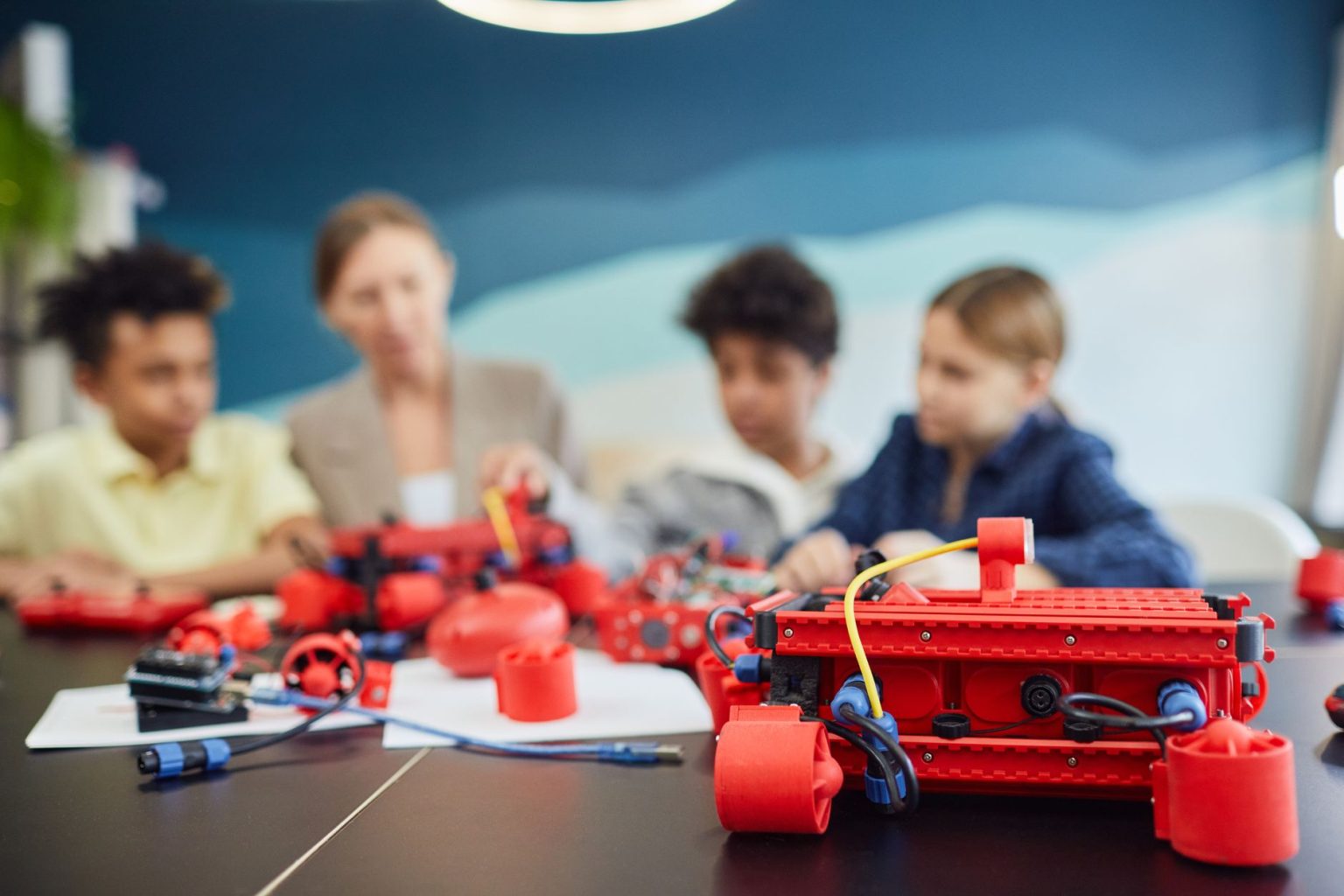 Grupo de crianças trabalha em um projeto de robótica em ambiente de educação tecnológica.